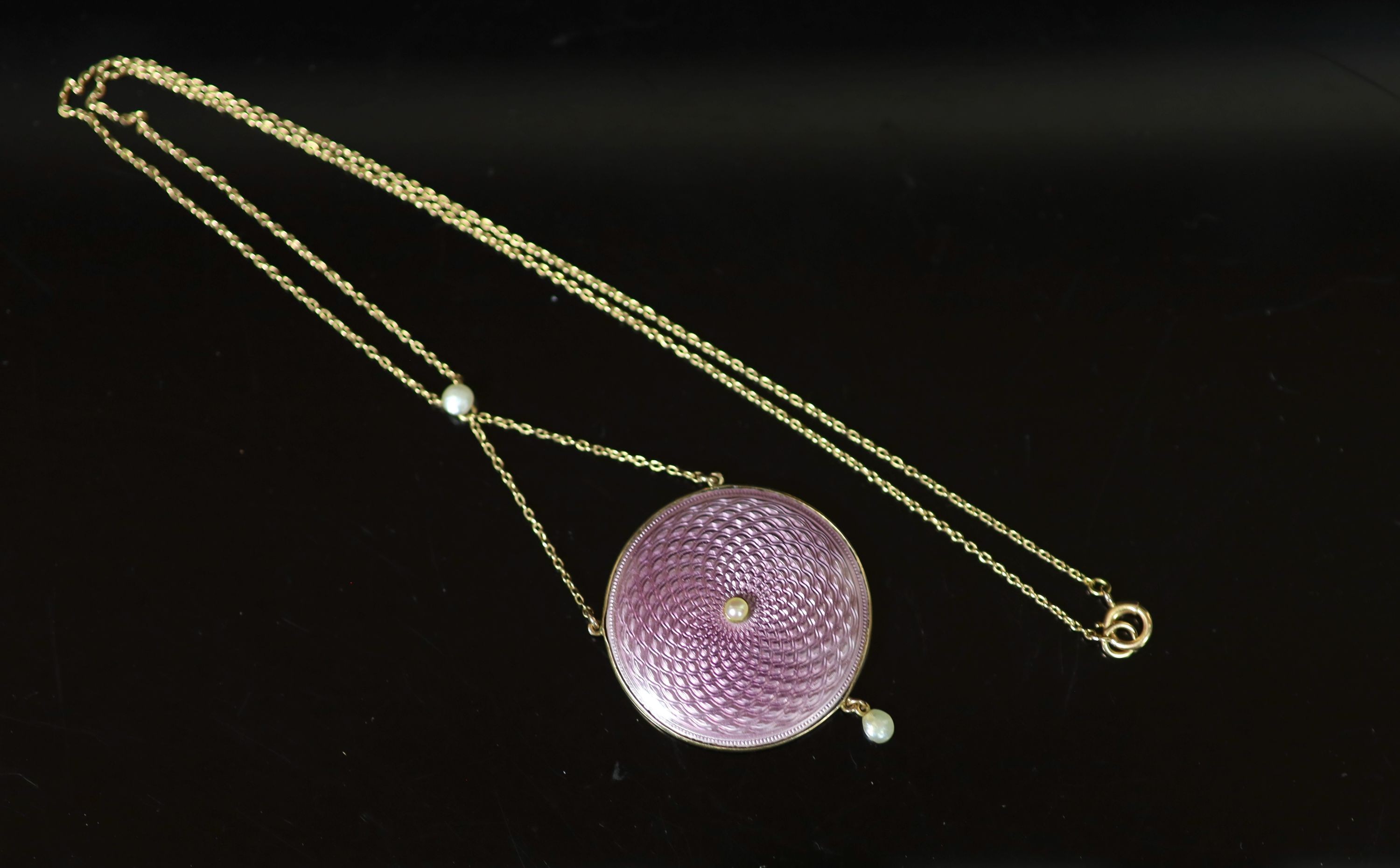 An Edwardian gold, pink guilloche enamel and seed pearl set drop circular pendant necklace